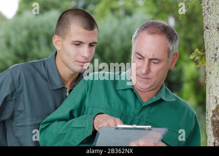 middle age farmer and supervisor analyzing checklist in farm Stock Photo