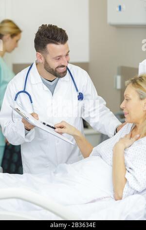 doctor explaining consent form to female senior patient Stock Photo