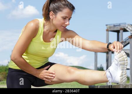 active woman stretches legs outdoor Stock Photo