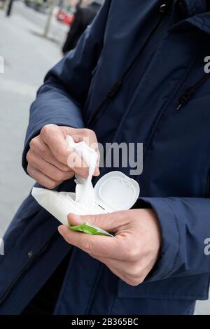closeup of a caucasian man on the street about to disinfect his hands with a wet wipe Stock Photo