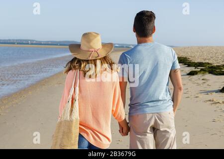 couple walking along the sea shore Stock Photo