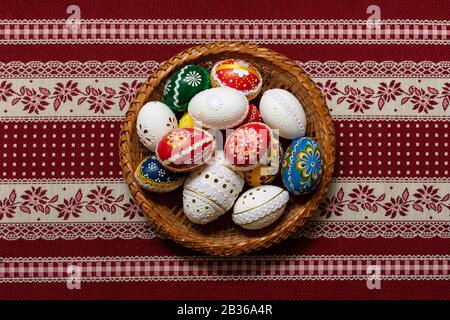 Traditional decorated Easter eggs in a basket on a table cloth. Stock Photo