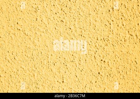 A wall with a lot of texture painted in neutral yellow, for background Stock Photo