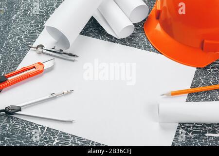 Engineer workplace with blueprints, compass, pencil and safety helmet Stock Photo