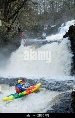 Kayakers take advantage of high water on the Mellte near Pontneddfechan to ride the Sgwd Isaf Clun-Gwyn falls in the Brecon Beacons, Wales UK Stock Photo