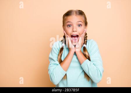 Wow. Closeup photo of beautiful pretty small lady hold hands on cheeks screaming of sale prices shopping open mouth wear blue pullover isolated beige Stock Photo