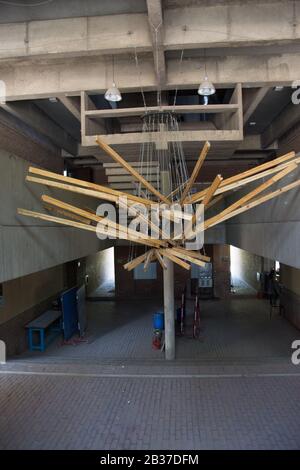 Ahmedabad / India / April 11, 2017: Hanging wood sculpture from the concrete structure on an university Stock Photo