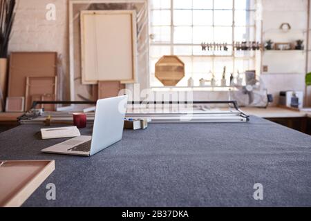 Laptop and mat cutter on a framing shop table Stock Photo