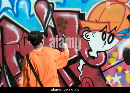 boy painting graffiti on wall Stock Photo