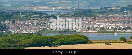 Isambard Kingdom Brunel rail bridge & modern road bridge over River Tamar with Torpoint urban landscape & Cornwall farming countryside  England UK Stock Photo