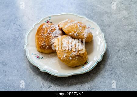 Mandazi is a slightly sweet East African Street Food; spicy, airy yeast doughnut dough made with coconut milk, flavored with cardamom and grated fresh Stock Photo