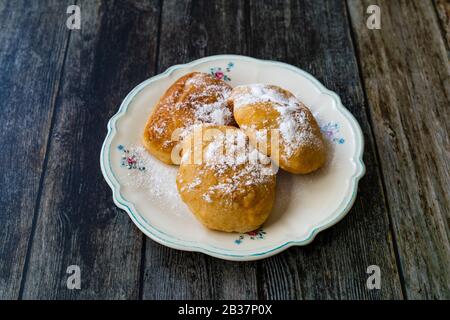 Mandazi is a slightly sweet East African Street Food; spicy, airy yeast doughnut dough made with coconut milk, flavored with cardamom and grated fresh Stock Photo