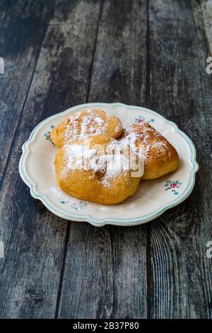 Mandazi is a slightly sweet East African Street Food; spicy, airy yeast doughnut dough made with coconut milk, flavored with cardamom and grated fresh Stock Photo