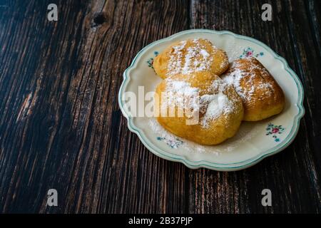 Mandazi is a slightly sweet East African Street Food; spicy, airy yeast doughnut dough made with coconut milk, flavored with cardamom and grated fresh Stock Photo