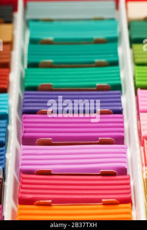 Plasticine in a box of multi-colored pieces in full screen, material for modeling. Close up. Stock Photo