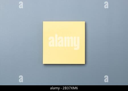 yellow sticky note with dramatic shade on grey background to add text copy space Stock Photo