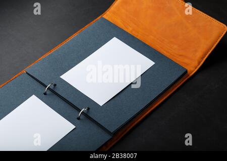 Photo album with empty space for photos, white frames on black paper. Album with empty space for photos the album cover is made of brown handmade genu Stock Photo