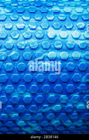 Abstract texture of a blue massage roller in the form of blue hexagonal cells. The entire screen as the background. Conceptual texture in the form of Stock Photo