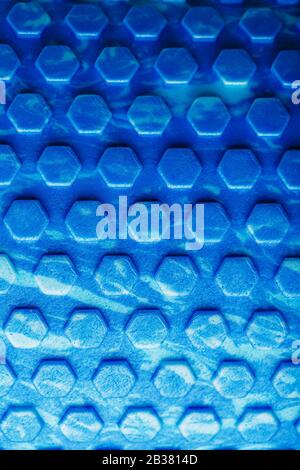 Abstract texture of a blue massage roller in the form of blue hexagonal cells. The entire screen as the background. Conceptual texture in the form of Stock Photo