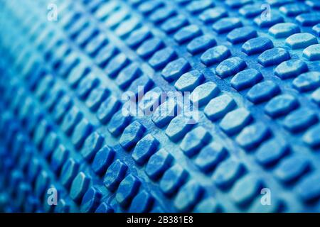 Abstract texture of a blue massage roller in the form of blue hexagonal cells. The entire screen as the background. Conceptual texture in the form of Stock Photo