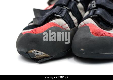 Worn climbing shoes requiring a full upper rubber replacement, isolated on white background. Stock Photo