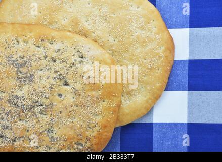 Greek sesame flatbreads on checked tablecloth Stock Photo