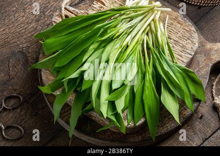 Fresh young wild garlic leaves on a rustic background Stock Photo