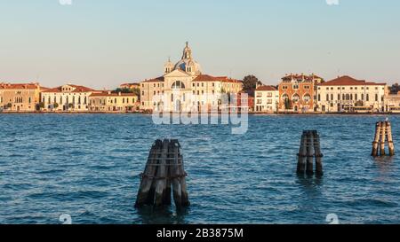 Pier wooden poles tightened together by rusty chains on canal in Venice Stock Photo