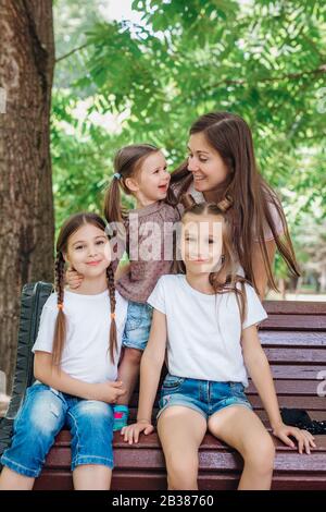 Lifestyle portrait mom and three daughters in happines at the outside in the park Stock Photo