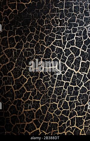 Black background in Golden grunge texture, natural texture cracks Golden elements. Conceptual effect of wear and tear. Full screen in the background Stock Photo