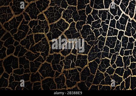 Black background in Golden grunge texture, natural texture cracks Golden elements. Conceptual effect of wear and tear. Full screen in the background Stock Photo