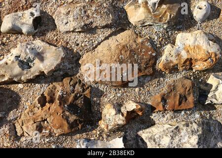 Old medieval castle wall in close up with flints and other stone set in mortar that could be used as a background. Stock Photo