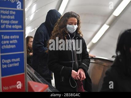 A woman at Green Park station on the London Underground tube network wearing a protective facemask. Stock Photo