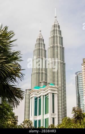 Amazing Petronas Twin Towers highest skyscrapers in Kuala Lumpur, Malaysia. Between palms view. Stock Photo