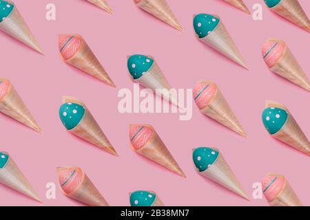 Pattern with colored decorated eggs in bamboo cones looks like ice cream on pink background. Concept of Easter, zero waste, ecology Stock Photo