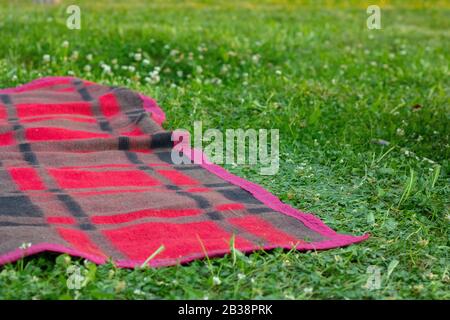Picnic background. Mat or rug on grass in sunny day in the park Stock Photo