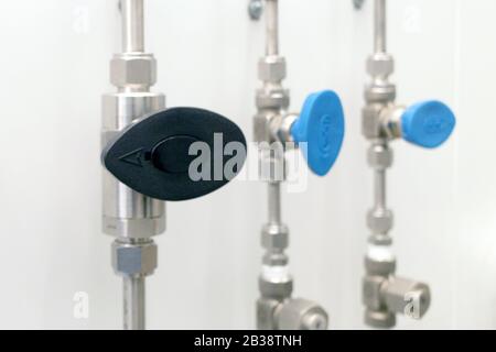 steel gas pipes with valves on the wall of gray color Stock Photo