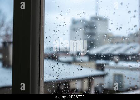 Window on a rainy day with small drops in it. Focus on the small raindrops Stock Photo