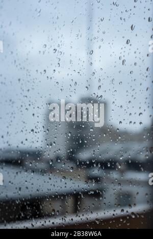 Window on a rainy day with small drops in it. Focus on the small raindrops Stock Photo
