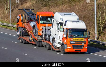 Convoi Exceptional Volvo truck; Motorway heavy loads, bulk Haulage new DAF delivery trucks, lorry, transportation, wide load delivery, transport, industry, oversize freight on the M6 at Lancaster, UK Stock Photo
