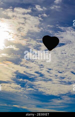 Hot air balloon shape of a heart in the blue sky. Aerostat, Airship ...