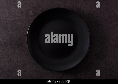 Black plate empty on slate background. Top view Stock Photo