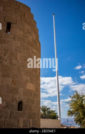 Jordan, Aqaba, tower of Aqaba Castle with Arab Revolt Flagpole in the background. Sunny winter day Stock Photo