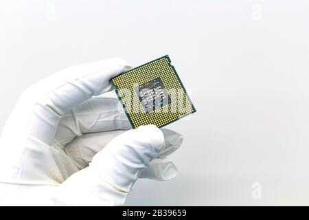 Hand in white glove holding a CPU computer processor microchip. Stock Photo