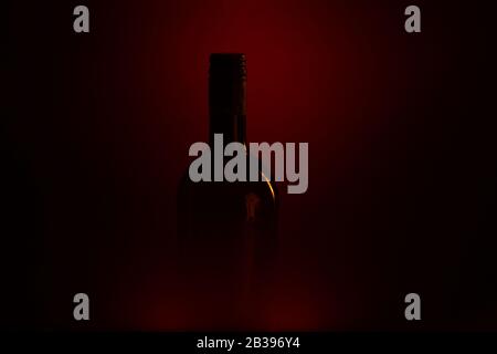 Studio shot of isolated dark black blurred red wine bottle silhouette (focus on bottle neck) Stock Photo