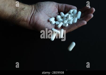 Medicine pills being thrown out by hand Stock Photo