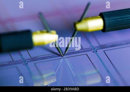 Manual probe system with needles for test of semiconductor on silicon wafer. Selective focus. Stock Photo