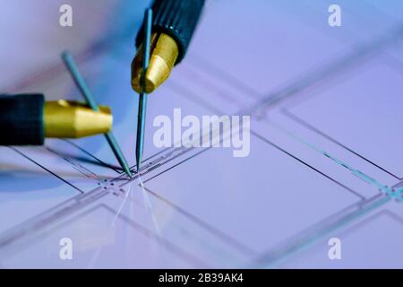 Manual probe system with needles for test of semiconductor on silicon wafer. Selective focus. Stock Photo