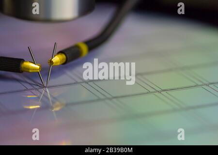 Close up of examining a sample of microchip transistor with probe station under the microscope in laboratory.A semiconductor on a silicon wafer Stock Photo