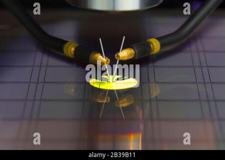 Close up of examining a sample of microchip transistor with probe station under the microscope in laboratory.A semiconductor on a silicon wafer Stock Photo